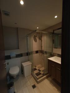 een badkamer met een douche, een toilet en een wastafel bij Peramos View Luxury Maisonette in Néa Péramos