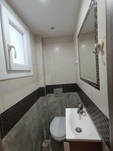 a bathroom with a toilet and a sink and a mirror at Peramos View Luxury Maisonette in Nea Peramos