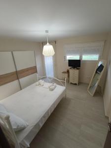 een slaapkamer met een bed en een televisie. bij Peramos View Luxury Maisonette in Néa Péramos