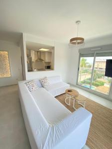 a living room with two white beds and a table at Àtico Espuma - Marenia´s Dream in Denia
