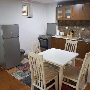 a kitchen with a table and chairs and a refrigerator at Apartments Baron Žabljak in Žabljak