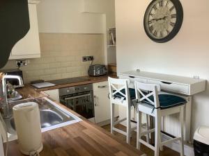 a kitchen with a sink and a clock on the wall at Lexus House 10mins- Durham Uni & Heritage Coast 