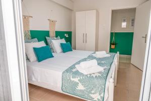 a bedroom with a large bed with blue and white pillows at Evangelia Rooms & Apartments - A in Asprovalta