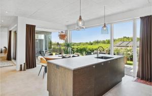 an open kitchen with a large window and a living room at 3 Bedroom Cozy Home In Børkop in Børkop