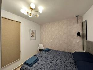 a bedroom with a bed with blue pillows on it at Apartment Camila in Sarandë