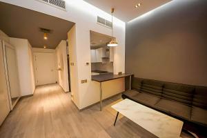 a living room with a couch and a kitchen at Upgraded studio close to Metro in Dubai