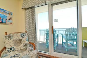 a room with a chair and a sliding glass door at Oceanfront TOP LOCATION MODERN RESORT Lazy River Huge Pool Oasis in Myrtle Beach