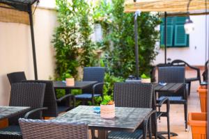 patio ze stołami, krzesłami i parasolem w obiekcie ALGHERO NOON w mieście Alghero