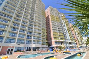 a view of a large apartment building with a swimming pool at Oceanfront TOP LOCATION MODERN RESORT Lazy River Huge Pool Oasis in Myrtle Beach