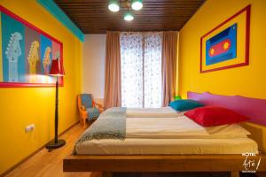 1 dormitorio con 1 cama en una habitación colorida en Art'e Boutique Hotel en Băile Tuşnad