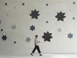 a woman walking past a wall with stars on it at Amnaya Resort Kuta in Kuta