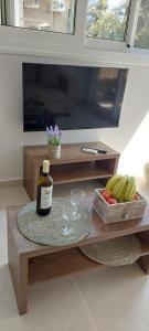 un tavolo con una bottiglia di vino e un vassoio di frutta di Ionian Paths a Perama