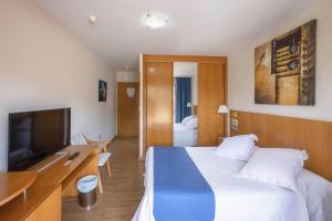 um quarto de hotel com uma cama e uma televisão em Villa De Llanes em Llanes