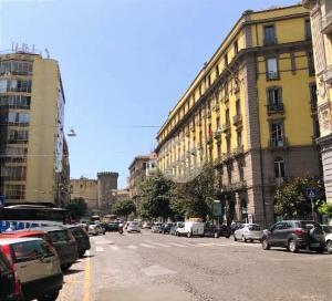 una calle de la ciudad con coches aparcados en la calle en Astrea, en Nápoles