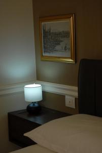une lampe assise sur une table à côté d'un lit dans l'établissement Borgo Santa Caterina 34, à Catane