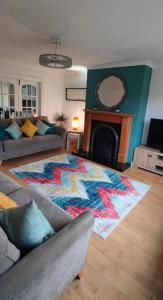 sala de estar con alfombra frente a una chimenea en The Bay house en Derry