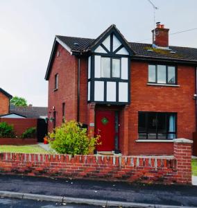 a red brick house with a red door at The Bay house in Derry Londonderry