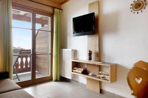een woonkamer met een flatscreen-tv aan de muur bij Naturalia Moarhof Natur Apartments in Laion