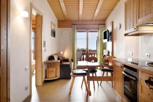 een keuken en eetkamer met een tafel en stoelen bij Naturalia Moarhof Natur Apartments in Laion