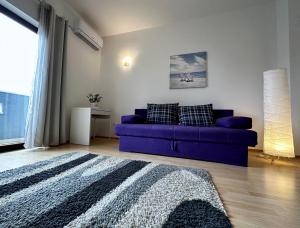 een woonkamer met een paarse bank en een raam bij Apartments Villa Anna Sonia in Podstrana