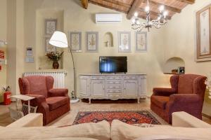 a living room with a tv and two chairs at Podere Vignola in Pontassieve