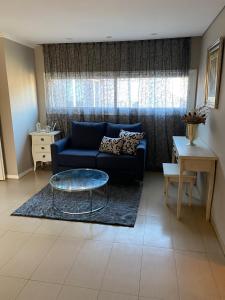 uma sala de estar com um sofá azul e uma mesa em Casa Guemes em Mar del Plata