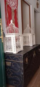 two white bird cages sitting on top of a chest at Casinha Amarela in Montargil