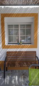 a bench sitting in front of a window at Casinha Amarela in Montargil