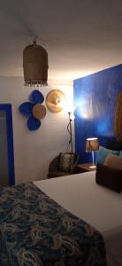 a bedroom with a bed and a blue wall at Casinha Amarela in Montargil