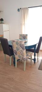 a dining room table with two chairs and a blue table at Casinha Amarela in Montargil