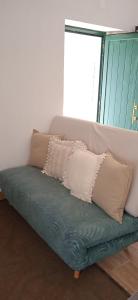 a green couch with pillows on top of it at Casinha Amarela in Montargil