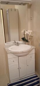 a bathroom with a white sink and a mirror at Casinha Amarela in Montargil