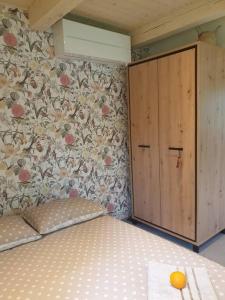PaenaseにあるMugavustega majake kahele Muhumaalのベッドルーム1室(ベッド1台付)、木製キャビネットが備わります。
