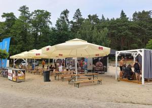 a group of tables and umbrellas on a beach at Apartamenty Wilczyca in Wilczyn