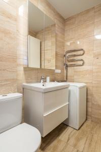 La salle de bains est pourvue d'un lavabo, de toilettes et d'un miroir. dans l'établissement 313 Apartment, à Palanga