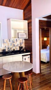 a kitchen with a table and stools in a room at VIA SPE - Pousada in Belo Horizonte