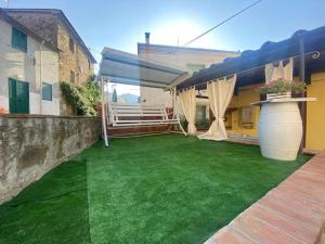 een achtertuin met een groen gazon en een huis bij La Vecchia Bottega in Montorio