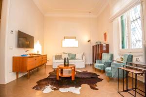 ein Wohnzimmer mit einem Sofa, einem Tisch und Stühlen in der Unterkunft Raffaello Apartment by Firenze Prestige in Florenz