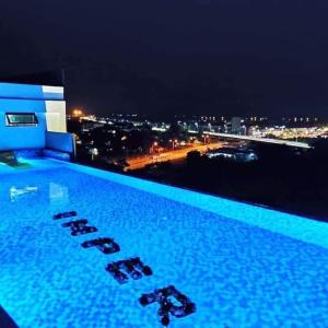 a swimming pool with a view of a city at night at D'yana Imperio Homestay in Alor Setar
