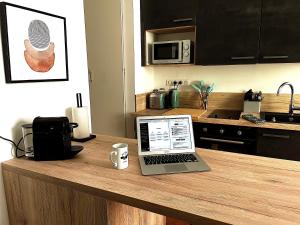 laptopa siedzącego na blacie kuchennym w obiekcie Charmant Studio beaux volumes #1 w mieście Dreux