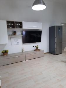 een woonkamer met een televisie en een koelkast bij Holiday Home Dolia Center in Dolianova