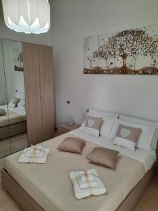 een slaapkamer met een groot bed en 2 handdoeken bij Holiday Home Dolia Center in Dolianova