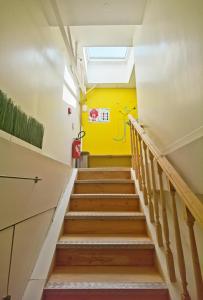 eine Treppe in einem Gebäude mit gelber Wand in der Unterkunft Ciel de Paris in Paris