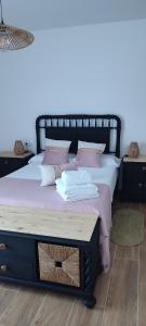 ein Bett mit einem schwarzen Rahmen und rosa Kissen in der Unterkunft El Cantón in Bogarra