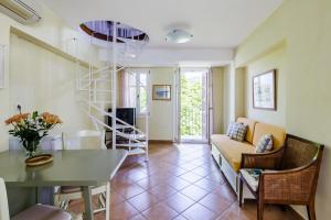 a living room with a spiral staircase and a table at Sentefi Maisonette in Skopelos Town