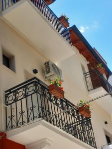 einen Balkon eines Gebäudes mit Topfpflanzen in der Unterkunft IL Fagio rooms in Margherita di Savoia