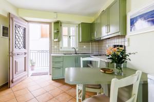 a kitchen with green cabinets and a table with flowers on it at Sentefi Maisonette in Skopelos Town