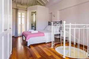 a bedroom with a white bed with a pink blanket at Sentefi Maisonette in Skopelos Town +10 photos