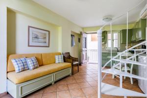 a living room with a couch and a staircase at Sentefi Maisonette in Skopelos Town