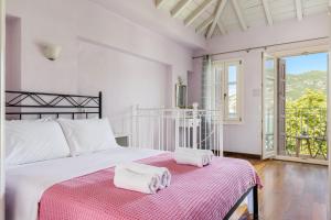 1 dormitorio con 1 cama con 2 toallas en Sentefi Maisonette, en Skopelos Town